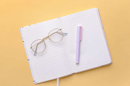 Blank notebook with pen on color backgroundの写真素材
