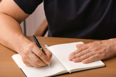 Man writing in notebook with penの写真素材