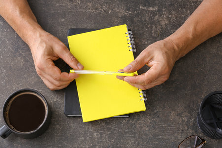 Man with notebook and pen on dark backgroundの写真素材