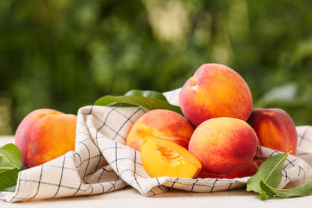 Ripe peaches on table in gardenの写真素材