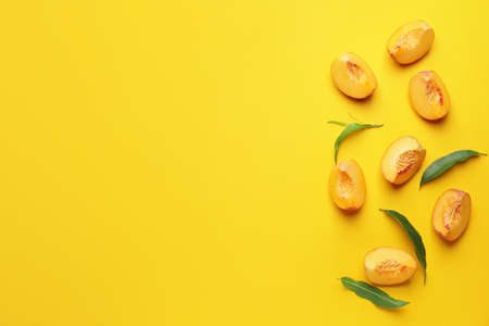 Cut ripe peaches on color background