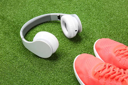 Sportive shoes and headphones on color backgroundの写真素材