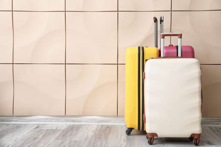 Packed suitcases near light wallの写真素材