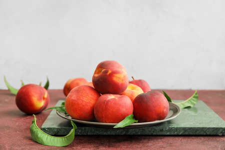 Tray with ripe peaches on table
