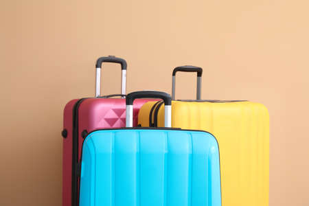 Packed suitcases near color wallの写真素材