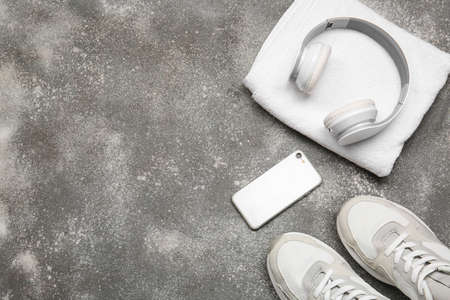 Sportive shoes, towel, mobile phone and headphones on gray backgroundの写真素材