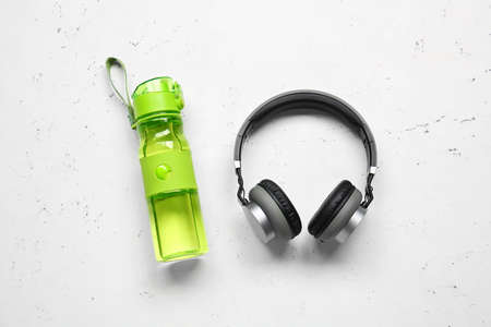 Bottle of water and headphones on light backgroundの写真素材