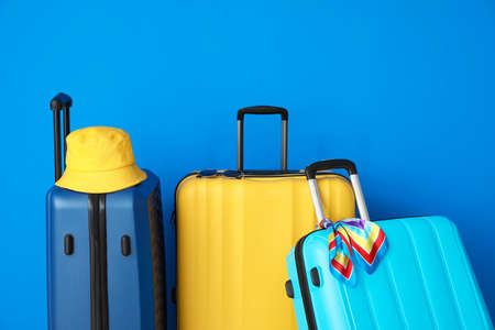 Packed suitcases near color wallの写真素材