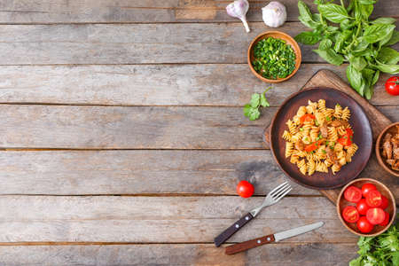 Plate with tasty pasta and chicken on tableの写真素材