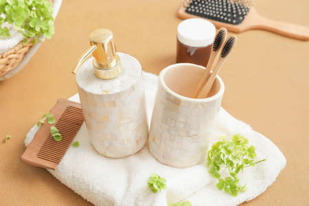 Composition of dispenser and cup with toothbrushes on tableの写真素材