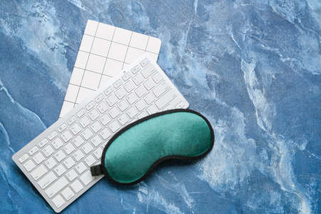 Sleep mask and keyboard on color backgroundの写真素材