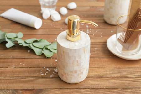 Dispenser and set of bath accessories on wooden tableの写真素材