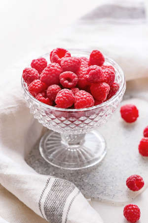 Bowl with ripe raspberries on white backgroundの写真素材
