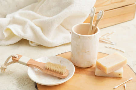 Wooden board with set of bath accessories on table