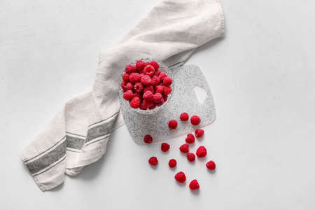 Bowl with ripe raspberries on white backgroundの写真素材