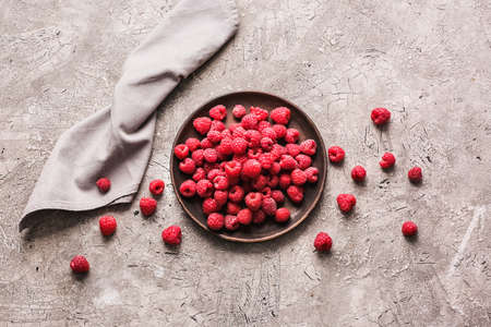 Plate with ripe raspberries on gray backgroundの写真素材