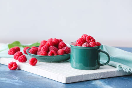 Plate with tasty ripe raspberries on tableの写真素材