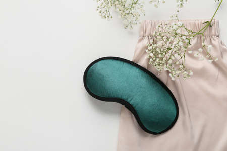 Sleep mask and pajamas on light backgroundの写真素材