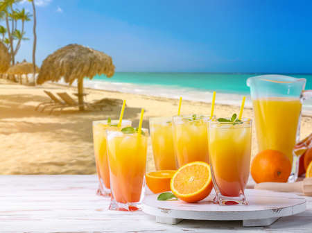 Glasses of tasty tequila sunrise cocktail on table at tropical resortの写真素材