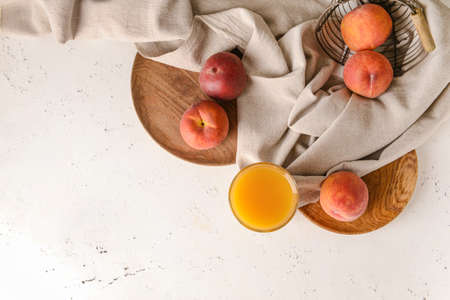 Glass of tasty peach juice on white background