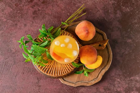 Glass of tasty peach juice on color backgroundの写真素材