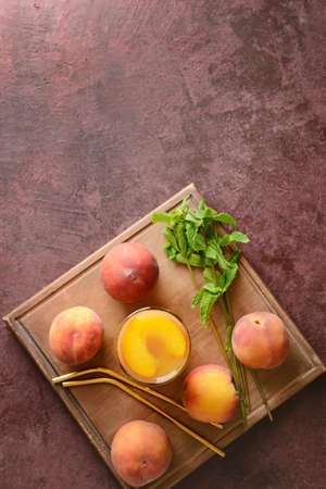 Glass of tasty peach juice on color backgroundの写真素材