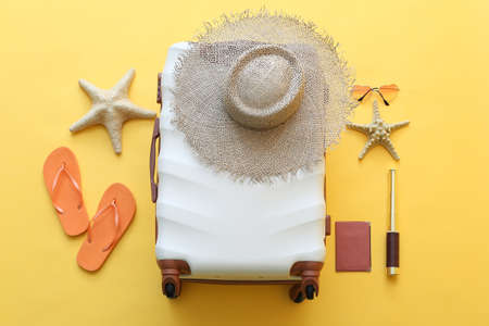 Packed suitcase with beach accessories on color background. Travel concept