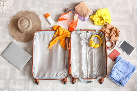 Suitcase with beach accessories on floor. Travel conceptの写真素材