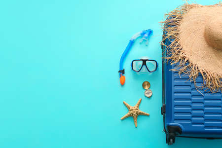 Packed suitcase with beach accessories on color background. Travel conceptの写真素材