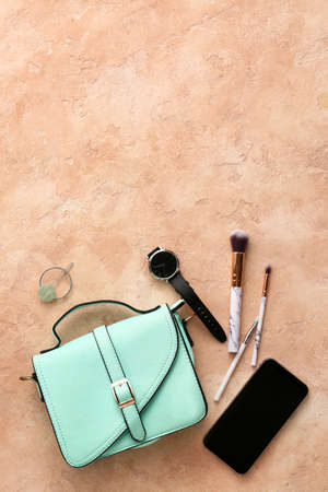 Stylish bag, accessories and mobile phone on color background