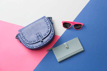 Stylish bag, sunglasses and purse on color backgroundの写真素材