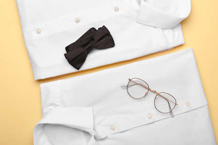 New male shirts, glasses and bow tie on color backgroundの写真素材
