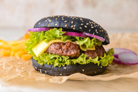 Tasty burger with black bun on tableの写真素材