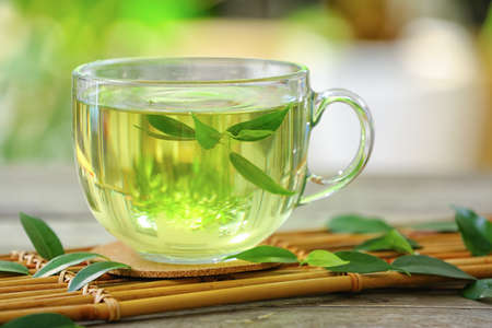 Cup of green tea with mint on blurred backgroundの写真素材