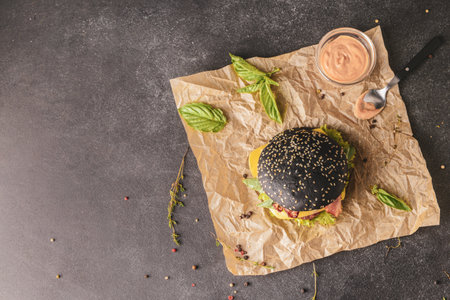 Tasty burger with black bun on dark backgroundの写真素材