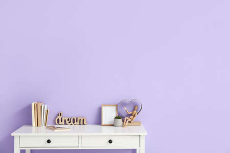 Stylish workplace with blank photo frame near color wallの写真素材