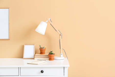 Stylish workplace with blank photo frames near color wallの写真素材