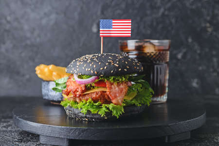 Tasty burger with black bun on tableの写真素材