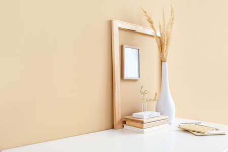 Stylish workplace with blank frames near color wallの写真素材