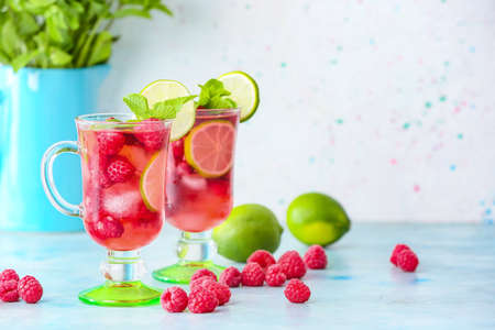 Cups of cold raspberry tea on tableの写真素材