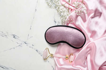 Pajamas, sleeping mask and massage tool on light backgroundの写真素材