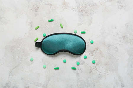 Sleeping mask and pills on light backgroundの写真素材