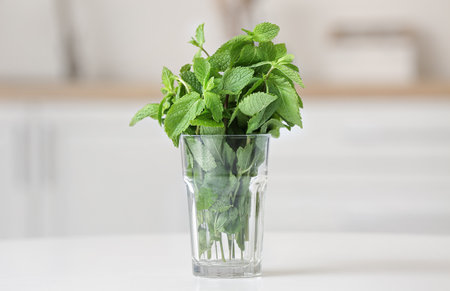 Glass with fresh mint on table in kitchenの写真素材