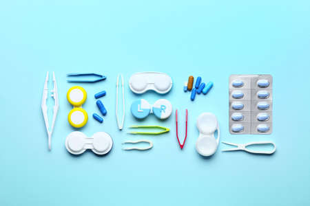 Containers with contact lenses, tweezers and pills on color backgroundの写真素材
