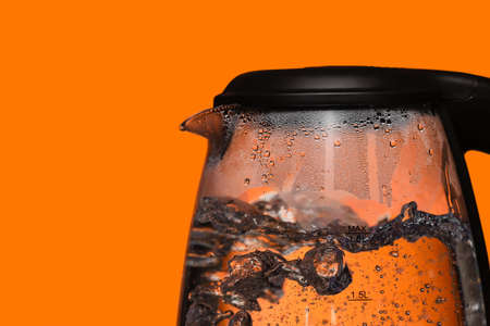 Transparent electric kettle with boiled water on color background, closeupの写真素材