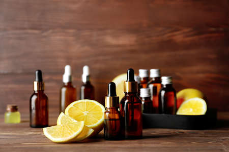 Bottles of lemon essential oil on wooden tableの写真素材