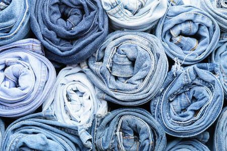 Many stylish jeans as background
