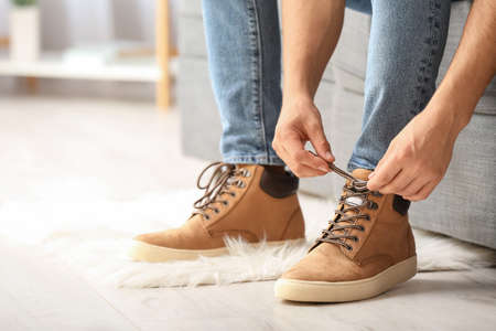 Young man putting on stylish shoesの写真素材