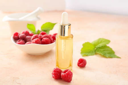 Bottle of raspberry essential oil on color backgroundの写真素材