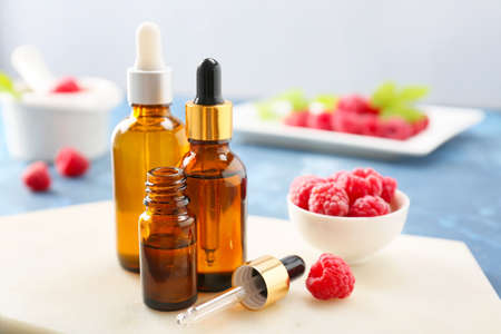Bottles of raspberry essential oil on tableの写真素材